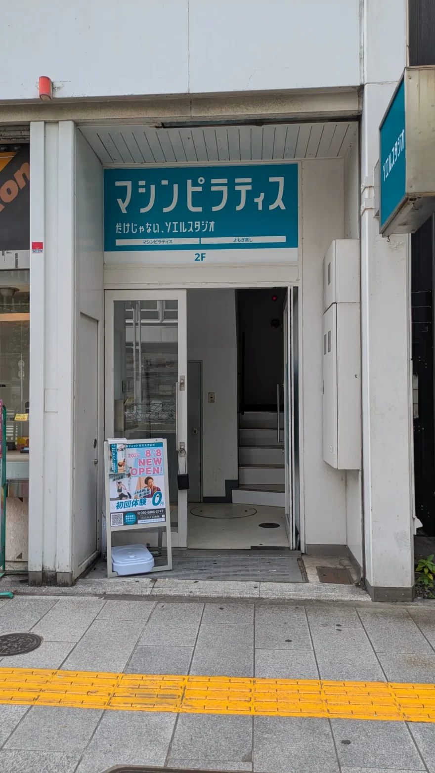 ソエルスタジオ名古屋伏見店の入口。2階へ上がる階段と、初回体験0円のA看板が置かれている