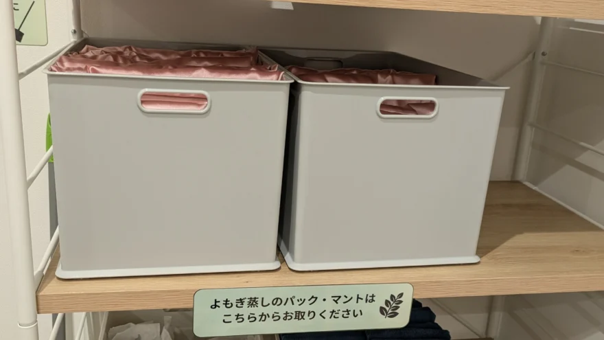 棚の収納ボックスに入れられた、よもぎ蒸し用のピンクのマント