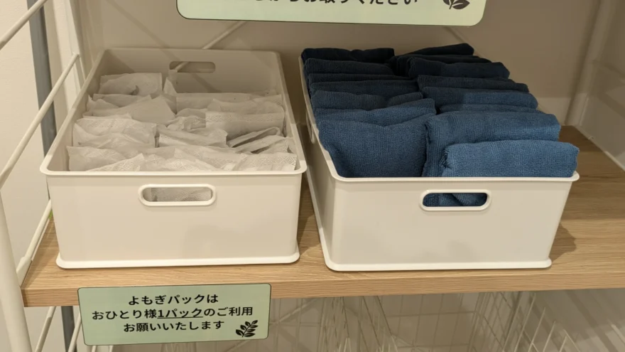 よもぎパックと青いタオルが、1人1つずつ取れるように並べられた棚