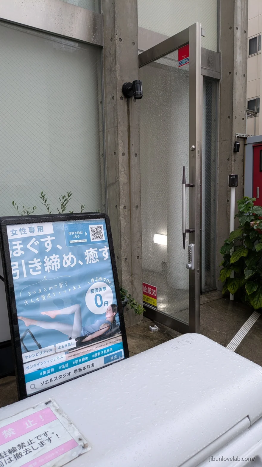 ソエルスタジオ堺筋本町店が入るビル1階の入口。ガラス扉の手前に女性専用と初回体験0円のA看板